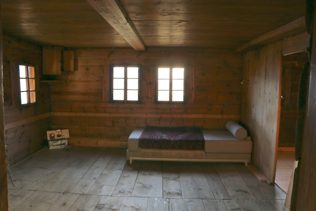 intérieur en bois d'une vieille maison, un lit, deux fenêtres